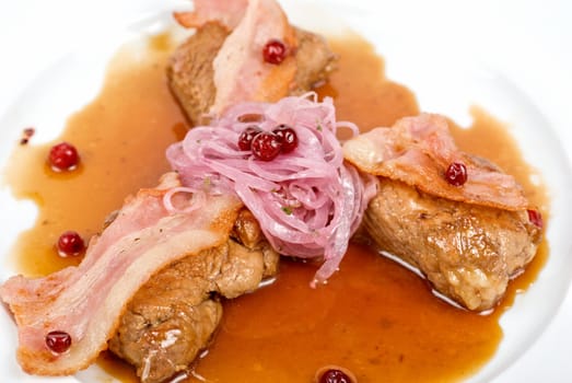 Roast pork meat with bacon, onion and cranberries