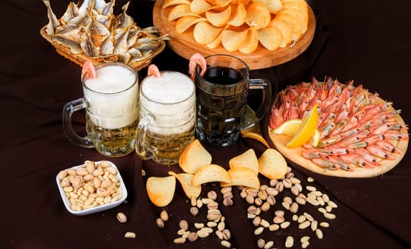 Beer and snacks set: chips, pistachio, shrimp and fish