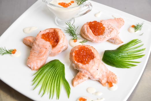 roasted salmon filet with red caviar, cucumbers and sauce