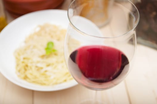 Italian Cuisine - Glass of Red Wine on Table in Front of Plate of Spaghetti - Shallow Depth of Field