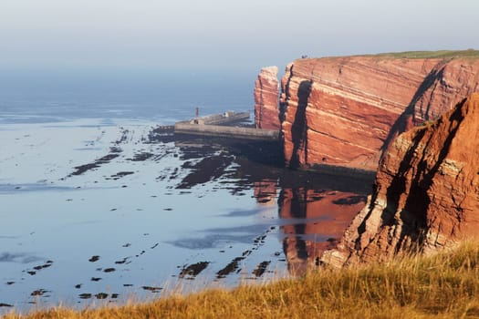Heligoland's cliffs in the morning light with reflection in the water