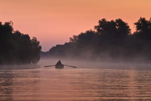 a fisherman&#039 s boat in the morning fog