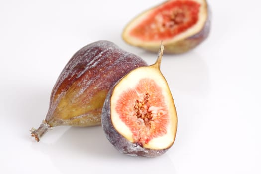 Whole and half figs on a white background