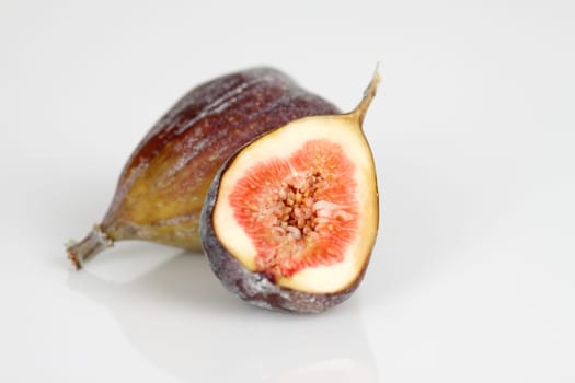 Whole and half figs on a white background