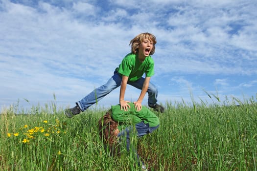 happy healthy kids playing leapfrog outdoors in summer
