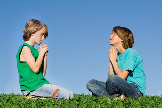 christian children praying outdoors at prayer group or bible camp