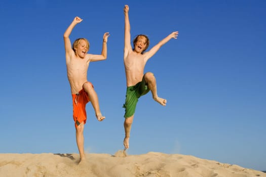 happy kids jumping on summer beach vacation