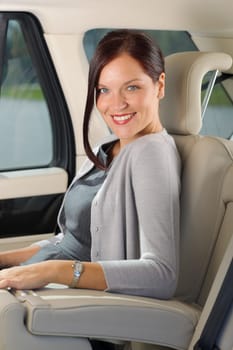 Executive businesswoman sitting in car leather backseat wear suit