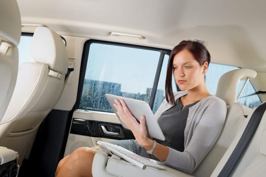 Attractive executive female manager work luxury car touch tablet computer