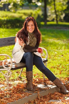 Autumn fashion smiling beautiful woman eat apple sunset nature park