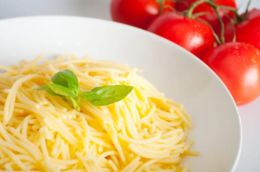 Spaghetti With Basil on White Plate and Fresh Tomatoes