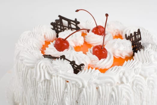 cream cake closeup with cherry on a grey