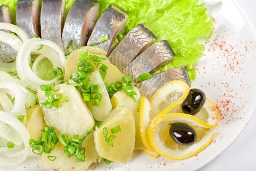 Tasty herring with potato and fresh vegetables