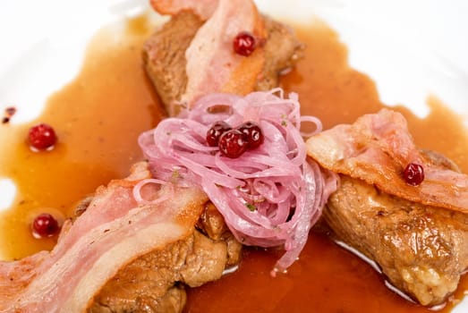 Roast pork meat with bacon, onion and cranberries
