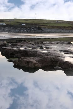 rock pool on beale beach co kerry ireland on a cold winters morning with turbine in the background