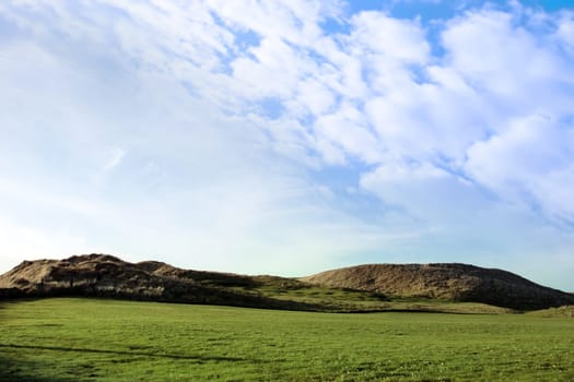 a flag waving on a links hole on a golf course in ireland
