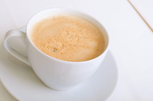 Creamy Espresso Coffee in White Cup on Table