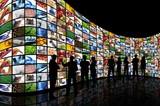 People silhouettes stood in front of a curved wall of screens