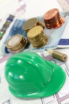 Construction helmet with euros on an apartment plan