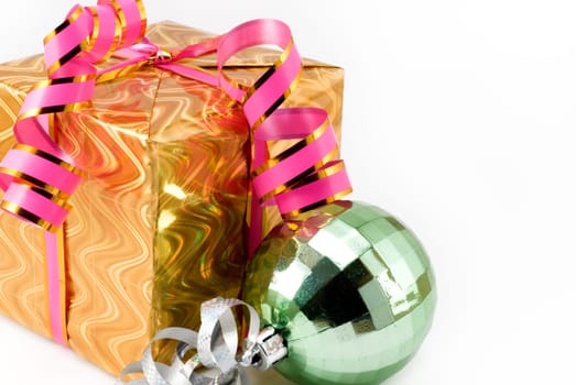 Gift box of yellow color with a pink tape and a brilliant sphere