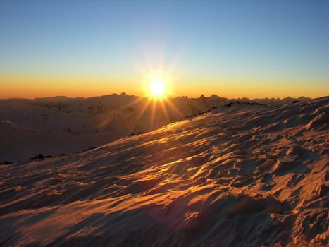 Sunset in snow-covered mountains of Caucasus