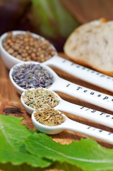 Old table-top selection of herbs and grains in measuring spoons
