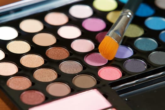 Make up colors and an application brush close up