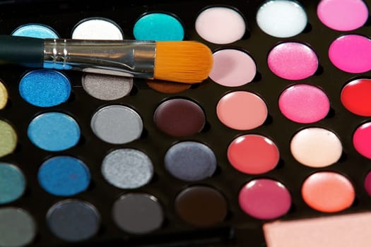 Make up colors and an application brush close up