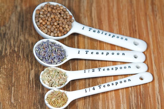 Old table-top selection of herbs and grains in measuring spoons