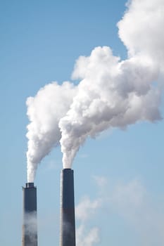 A tall smokestack spewing out dirty polluted smoke