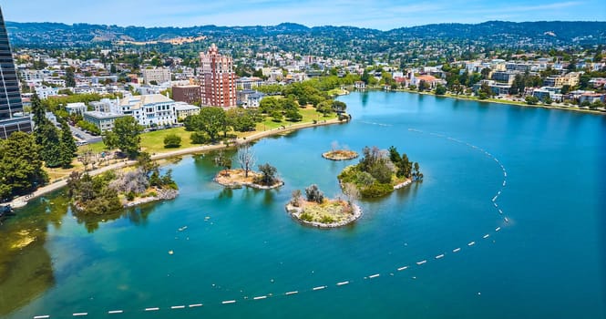 Image of Pelican Island and other small islands on Lake Merritt with aerial of Oakland City residential area