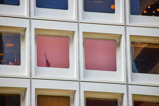 Image of Close up of square windows with pink lighting and reflected American flag