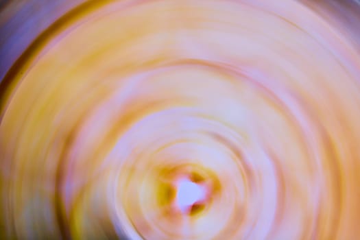 Image of Circular abstract ripple of orange with white and pink center with purple on outer rim