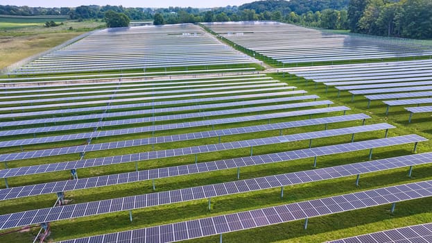 Image of Aerial over horizontal rows of solar panels on solar farm