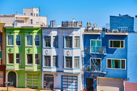 Image of Three houses in compact row with clear blue sky overhead in California