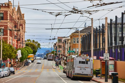 Image of Clean Air Vehicle with second bus pulled over on hill with cables over street for green energy