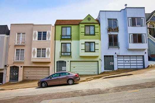 Image of Three houses touching with unique gates in front of entrance doorway and car on street