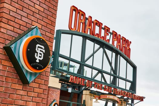 Image of Close up logo of Oracle Park with blurry entrance sign for sports stadium