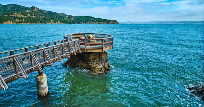 Image of Elephant Rock aerial with coast across bay and blue sky with purple hued clouds