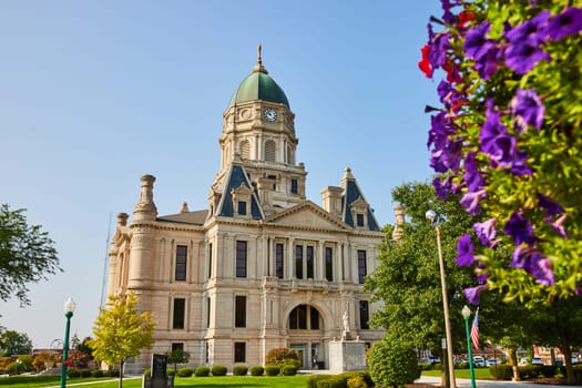 Image of Columbia city courthouse with red and purple flowers on side of shot on sunny day