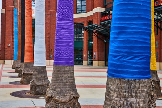 Image of Rainbow wrapped palm tree trunks in front of Oracle Park entrance