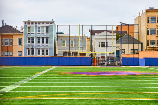 Image of Football field clean view with residential apartments and houses behind field goal post