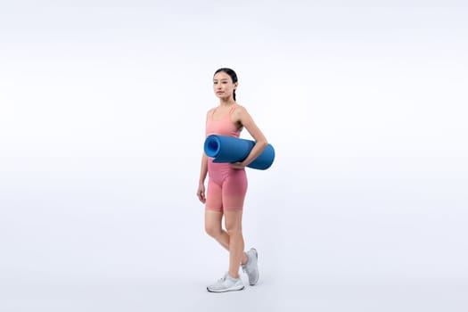 Young attractive asian woman portrait in sportswear with exercising mat. Healthy exercise and workout routine lifestyle concept. Studio shot isolated background. Vigorous