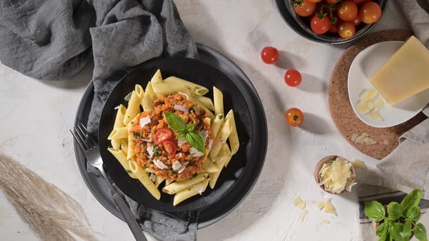 Vegetarian lentil Bolognese sauce penne pasta on a dark background. Healthy eating concept.