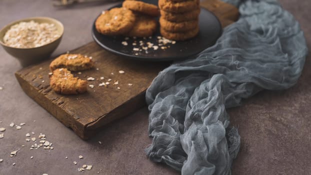 Homemade oatmeal raisin cookies with cup of cappuccino on rustic background.