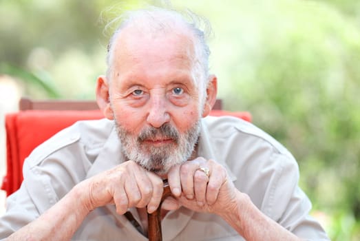 healthy happy old age senior man leaning on walking stick