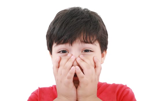 Preschool aged boy with his hand/fists over his mouth  looking embarrassed, worried or unsure. Isolated on white.