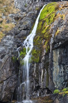 a beautiful waterfall on a mountain slope