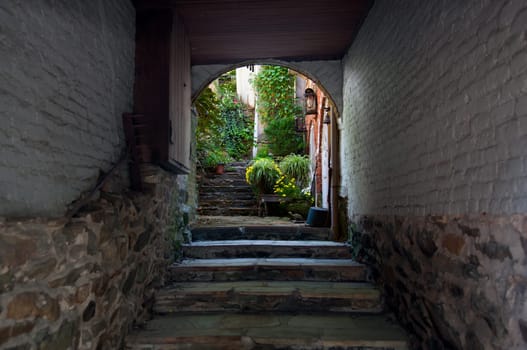 Old brick alley and stone steps lead to a hidden garden in old town