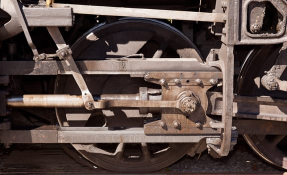 Close detail image of the drive wheel of an old steam locomotive engine